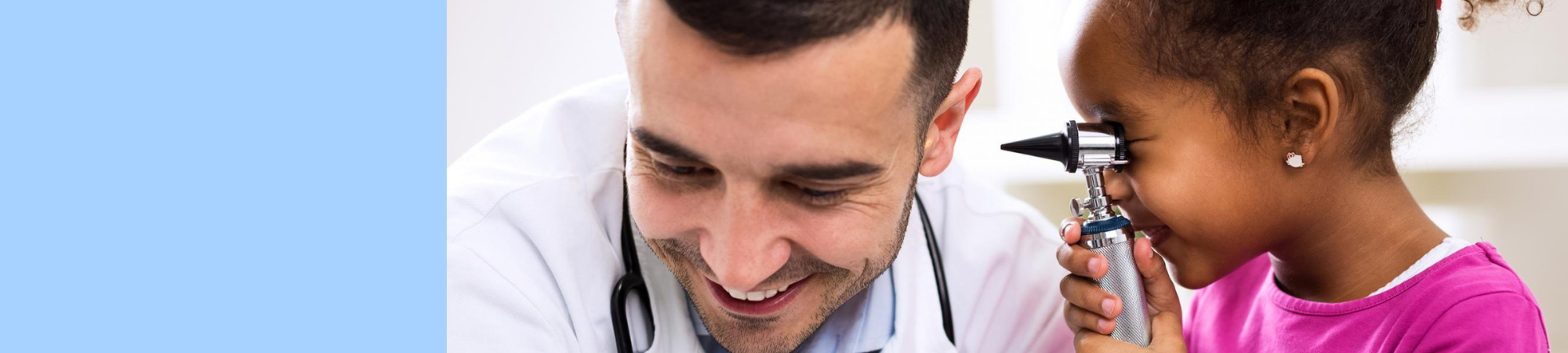 little girl looking into ear of doctor