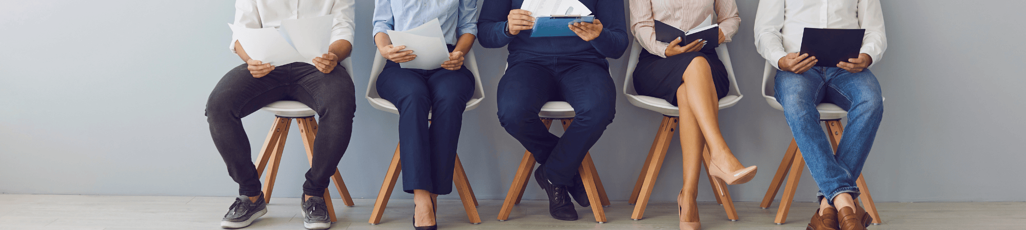 people in chairs holding resumes or other paperwork